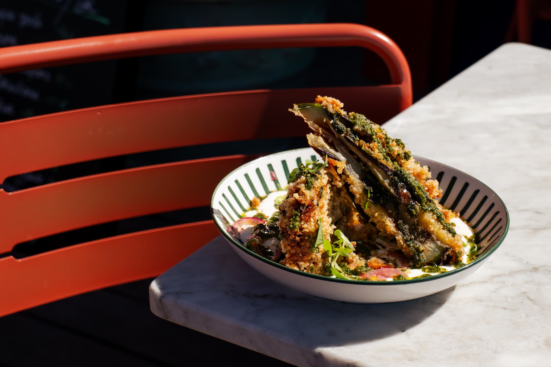 Aubergines panées au pesto servies en terrasse au soleil
